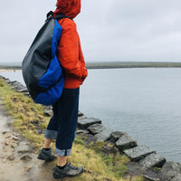 Blue-Turtleback-outdoor-swimming-bag-on-someone's-back-looking-out-across-the-water