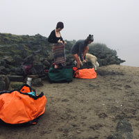 two women getting changed in Swim Feral Turtleback swim bags on the beach by the water