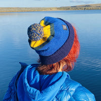 Woman wearing a blue Swim Feral hat looking out to the water before outdoor swimming