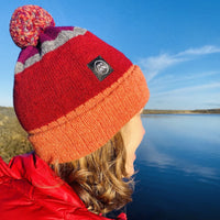 Woman wearing a red Swim Feral Hat looking out to the water before outdoor swimming