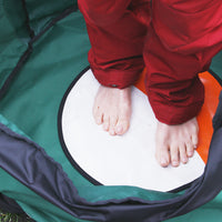 Picture of a woman feet on the insulated mat inside the Swim Feral Turtleback swim bag